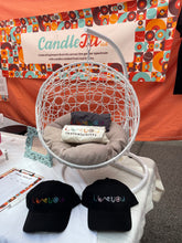 Load image into Gallery viewer, Boob themed baseball hats on a table at a market outside
