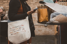 Load image into Gallery viewer, Diversititties tote bag at local market
